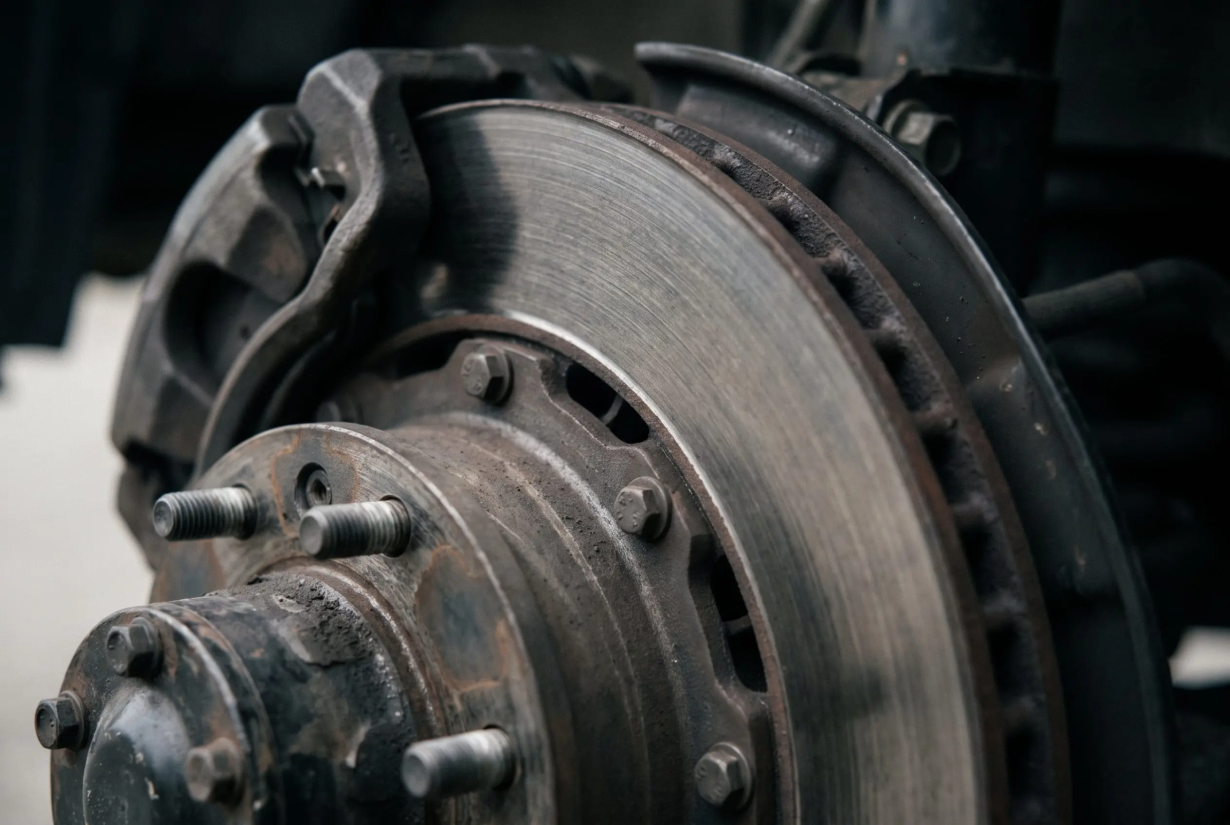 Ventilated disc brake rotor and caliper under warm workshop lighting