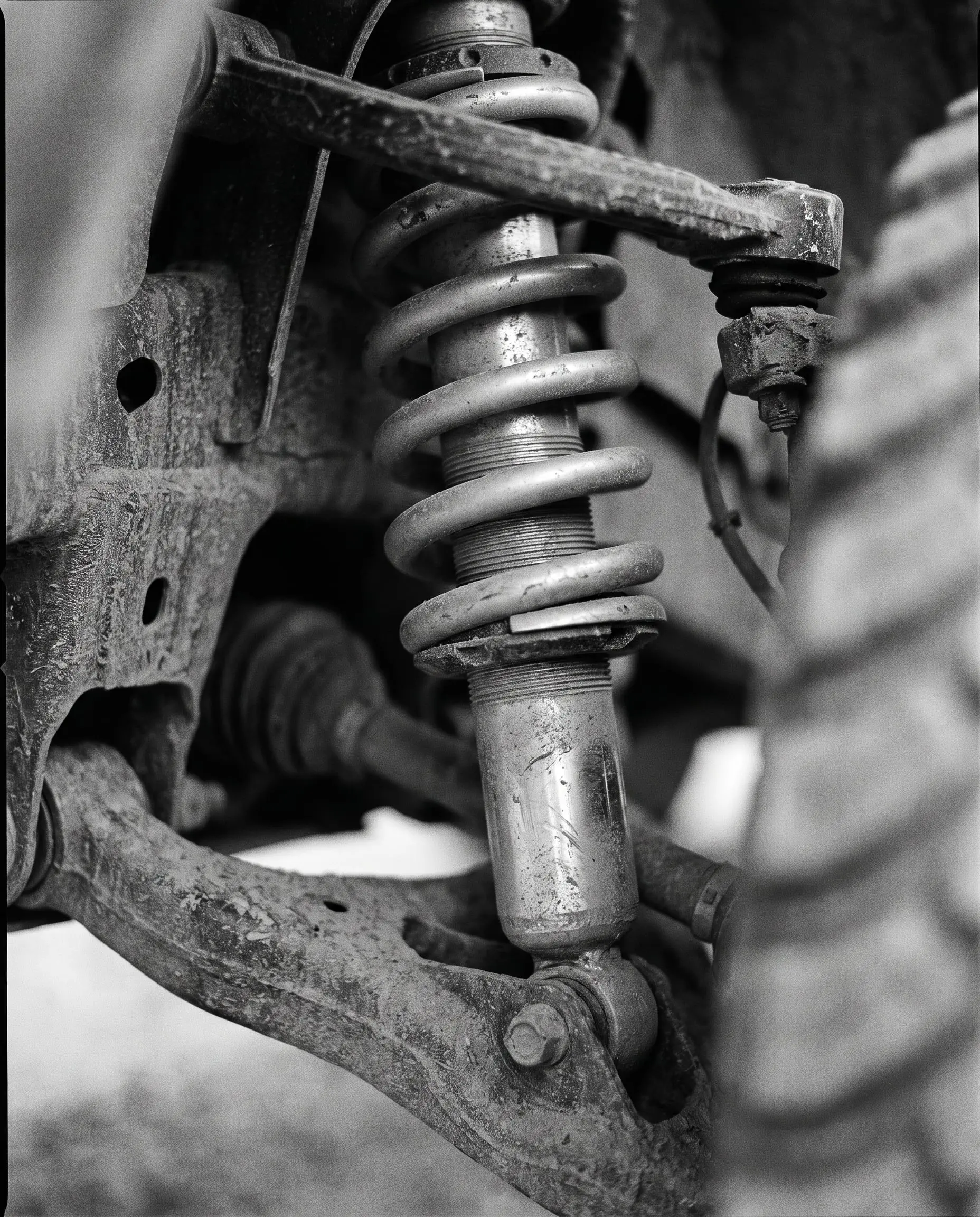 Heavy-duty off-road coilover suspension under workshop lighting